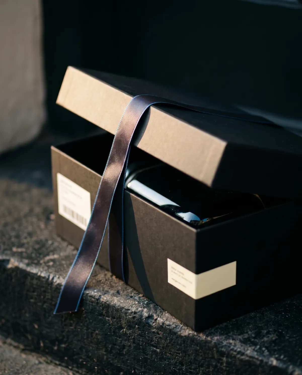 Half-open black gift box tied with a ribbon
