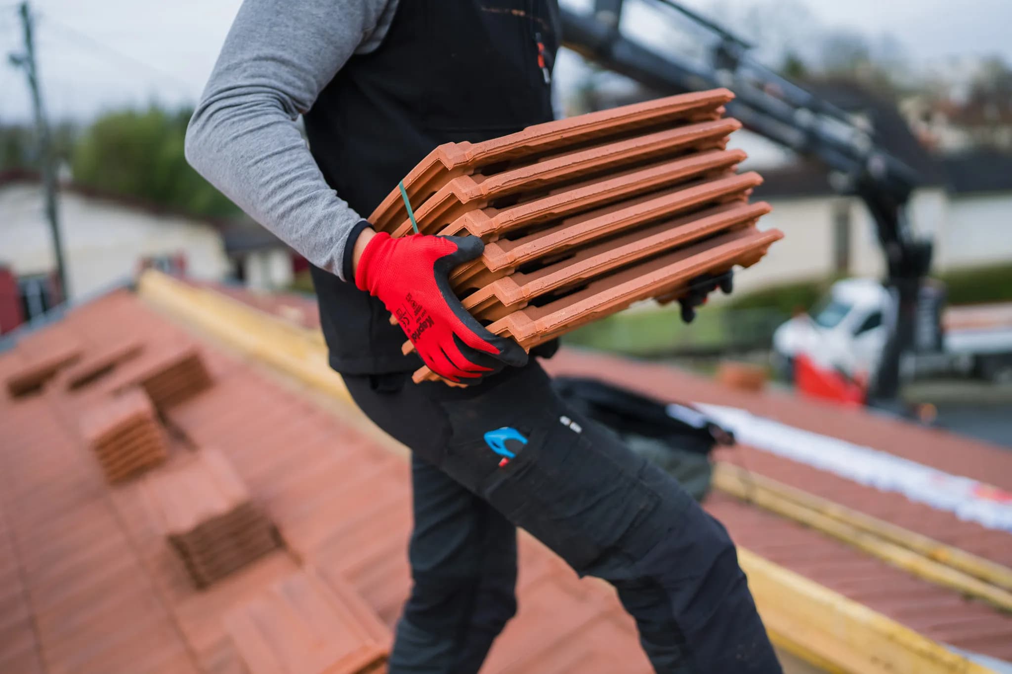 Roofer carrying tiles on a building site