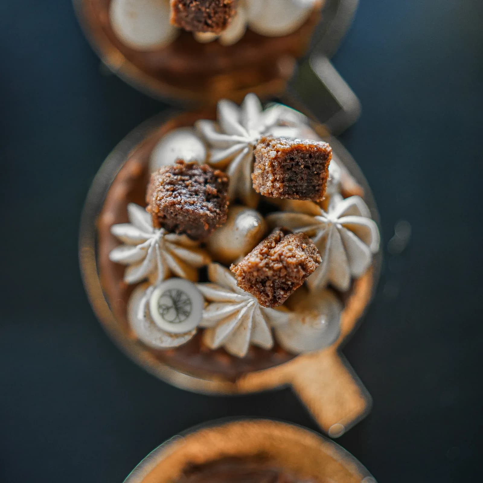 Desserts in glasses seen from above, with meringues and diced cake