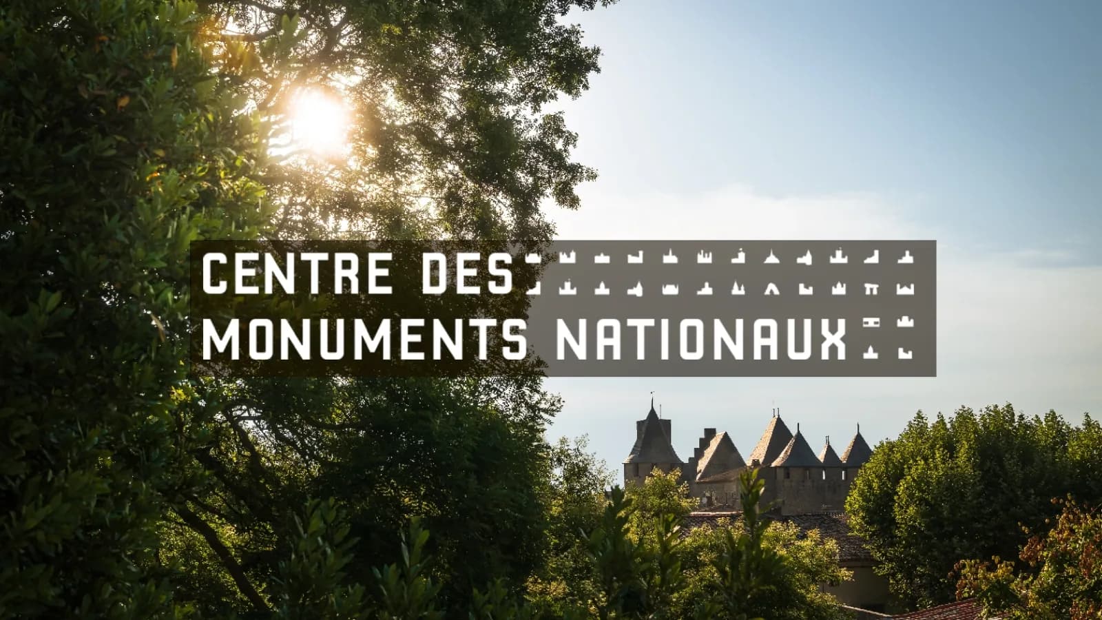 The Cité de Carcassonne behind the trees, with the Centre des monuments nationaux logo