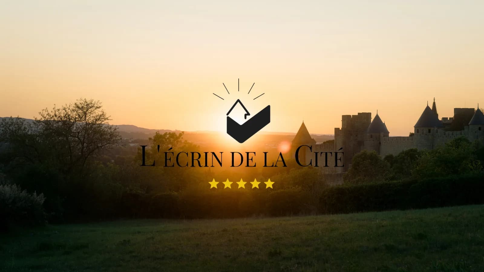 Logo de L'Écrin de la Cité ante las murallas de Carcasona, al atardecer