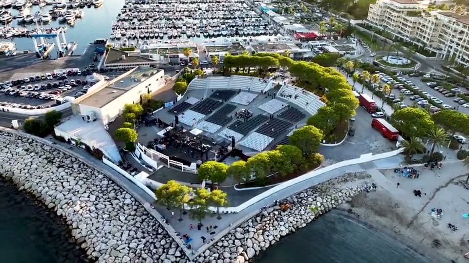 Open-air concert by a harbour, seen from the air