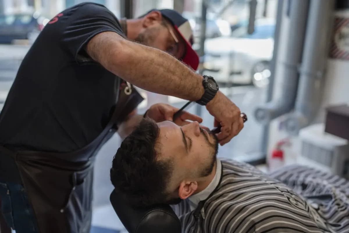 Barber trimming a client's beard