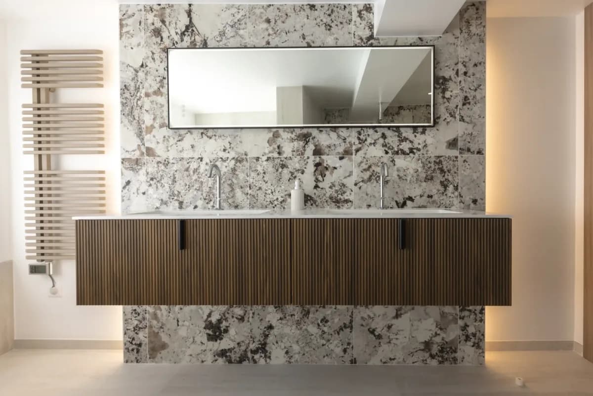 Wooden vanity unit against a veined stone wall
