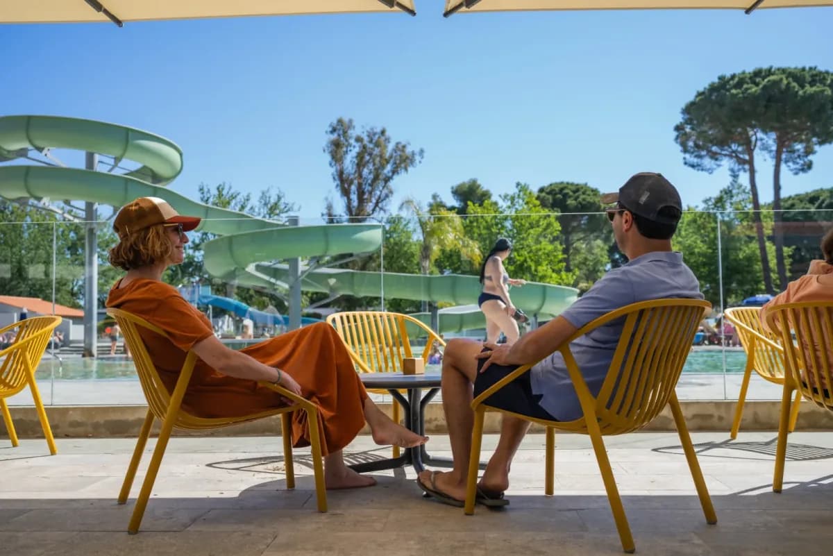 Couple on a terrace beside pools with waterslides