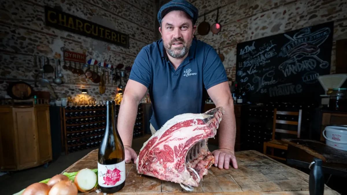 Portrait in the dining room, behind a rib of beef and a bottle of wine
