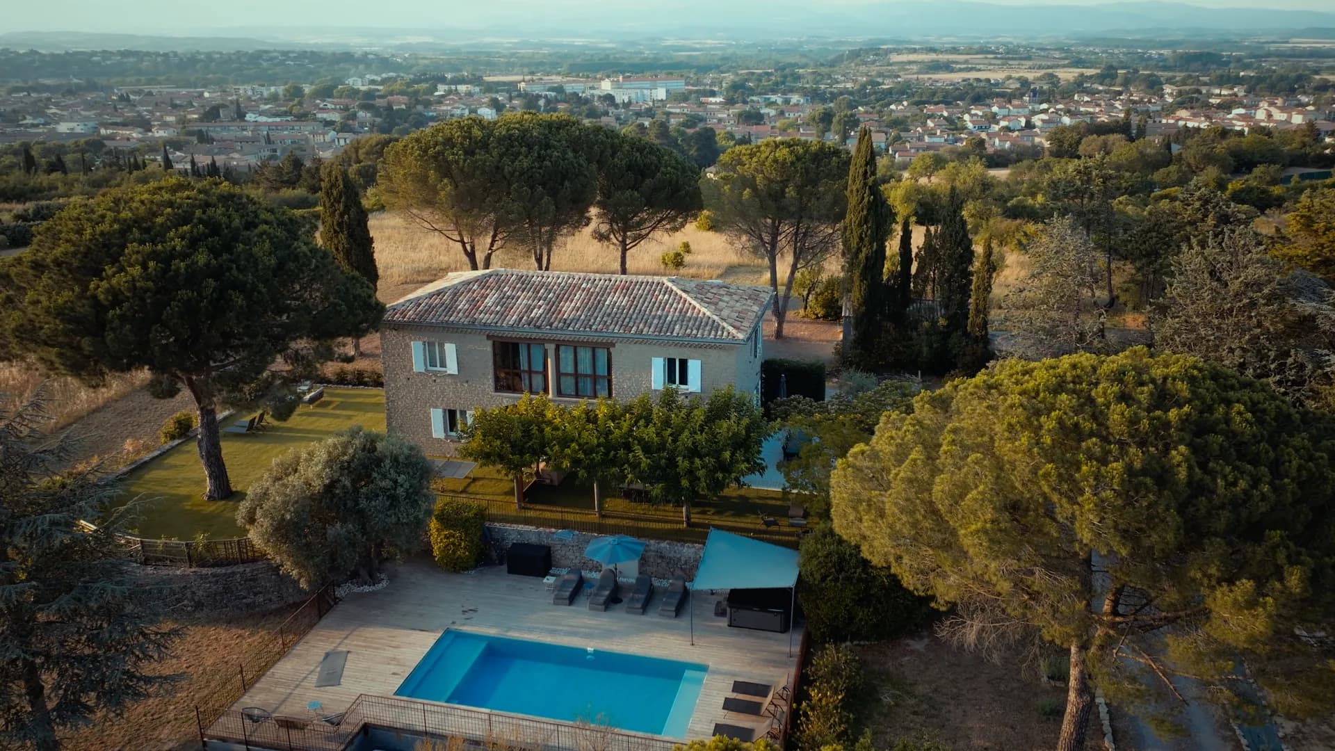 Une villa avec piscine au milieu des pins, vue du drone