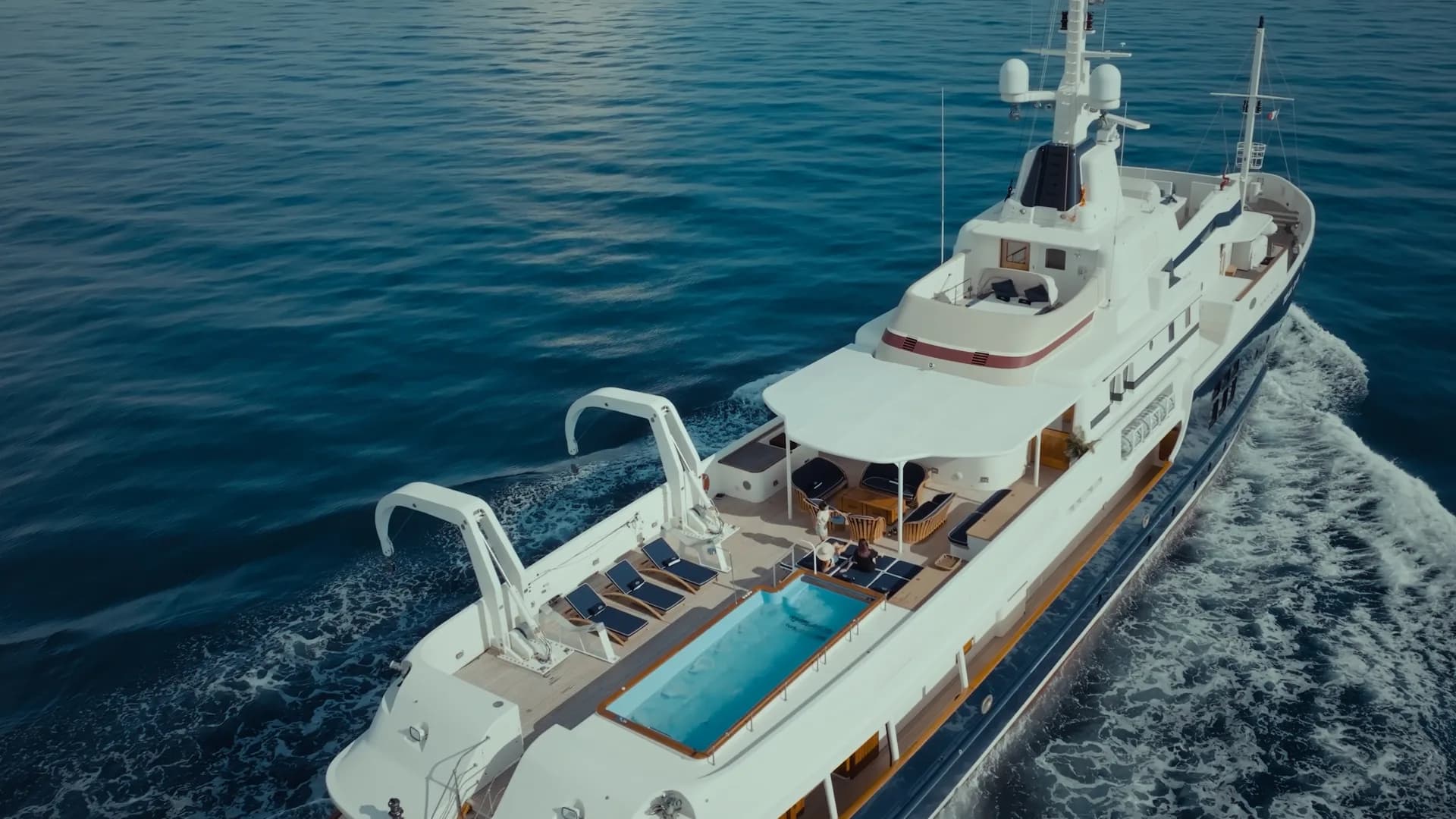 Un superyacht avec piscine sur le pont, en mer, vu du drone